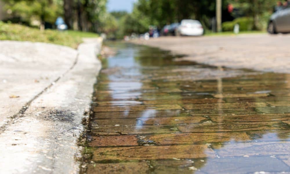 Stormwater runoff flowing along a curb and gutter drainage system in Waxahachie, Texas